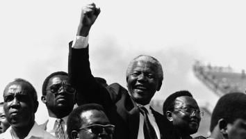 Nelson Mandela steekt juichend zijn vuist in de lucht