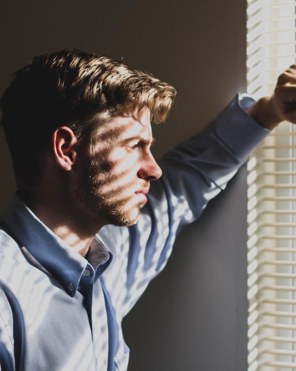 een jongen kijkt uit het raam