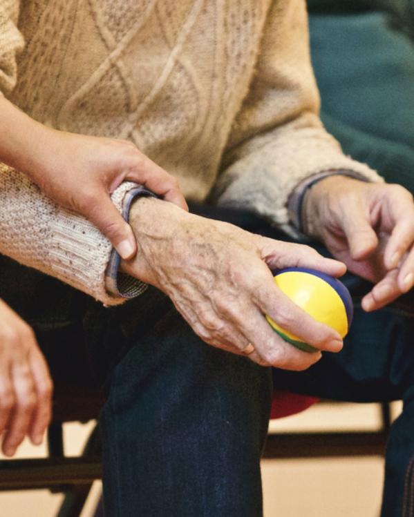 vrouw legt haar hand op die van een oudere man