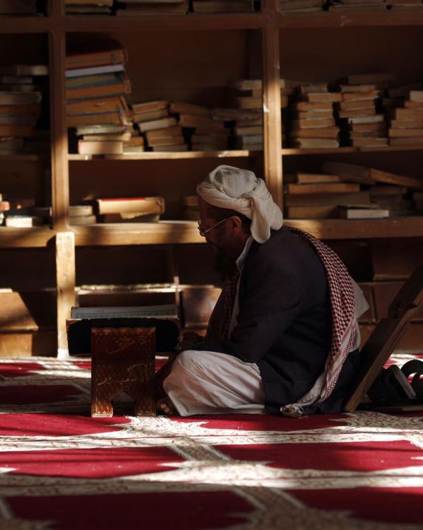 een man lees de koran in sanaa