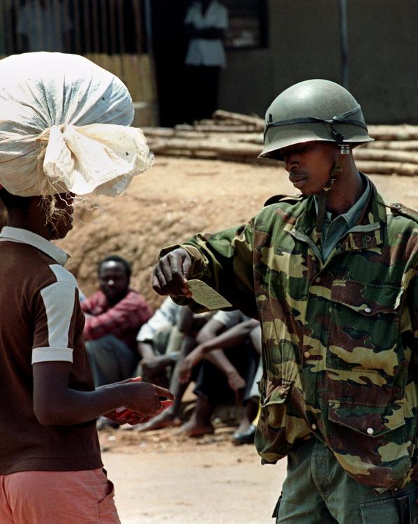 rwandese regeringssoldaat controleert de identiteitspapieren