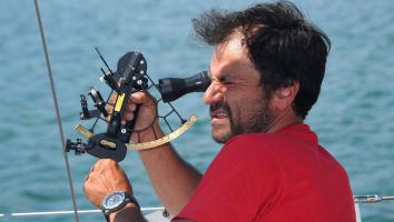 Man kijkt door een sextant instrument op zee