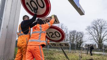 werknemers vervangen snelheidsborden langs de snelweg