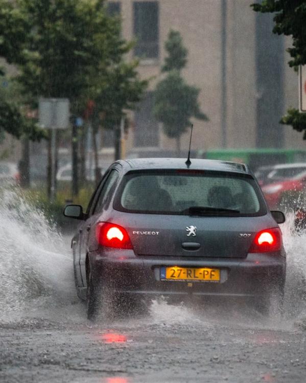 auto rijdt door hoog water heen