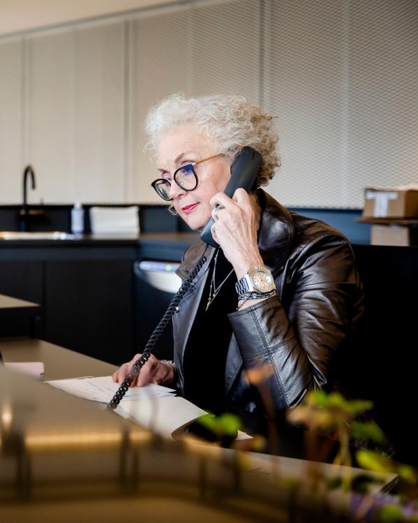 een werkende vrouw neemt de telefoon aan bij de receptie