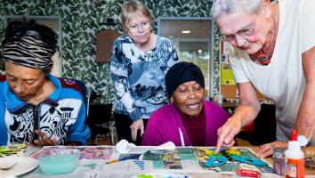 een groepje oudere vrouwen aan het schilderen