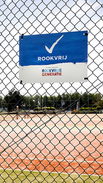 Bord naast sportveld met daarop een vinkje met Rookvrij