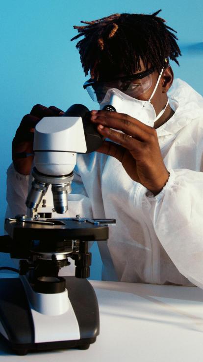 Een onderzoeker kijkt met mondkap om in een stethoscoop