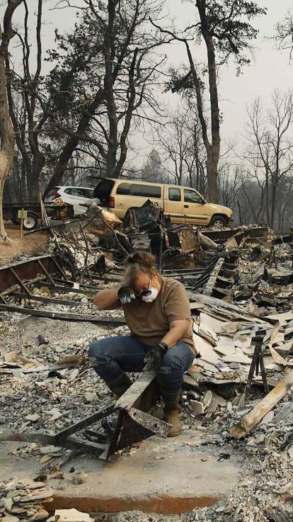 een Amerikaanse burger vol verdriet nadat het huis is afgebrand door een bosbrand