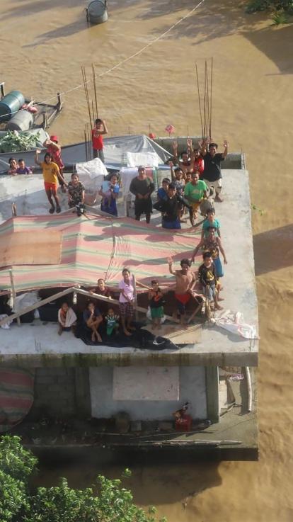 mensen schuilen op het dak vanwege overstromingen