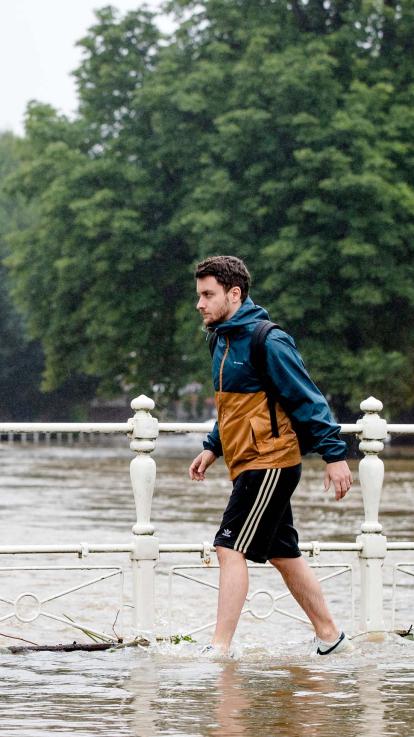 een man loopt door een overstroomd gedeelte van Valkenburg