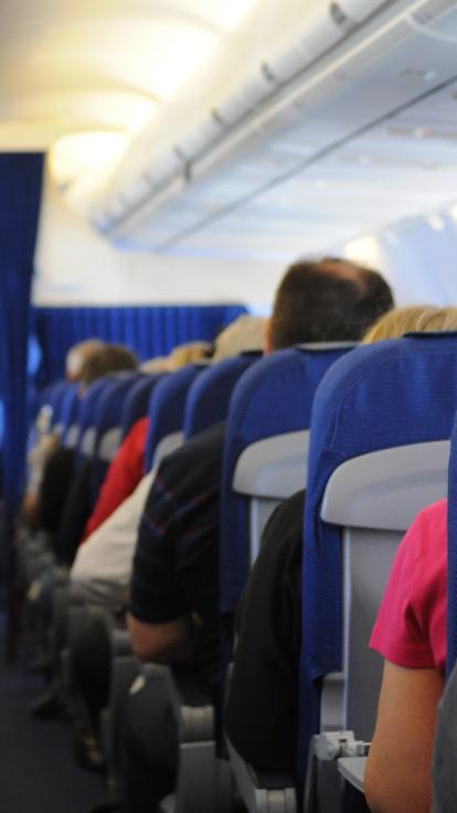 Rijen vliegtuigstoelen en de ruggen van passagiers