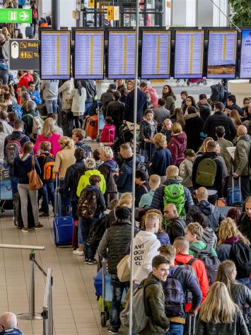 Grote groep reizigers op de luchthaven schiphol