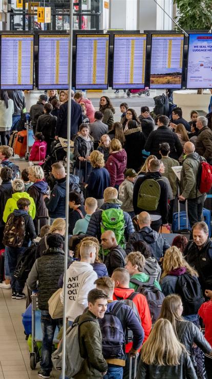 Grote groep reizigers op de luchthaven schiphol