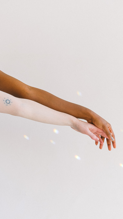 Twee armen met verschillende huidskleuren.