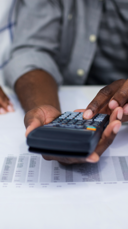 Man typt op rekenmachine naast brief met rekeningen