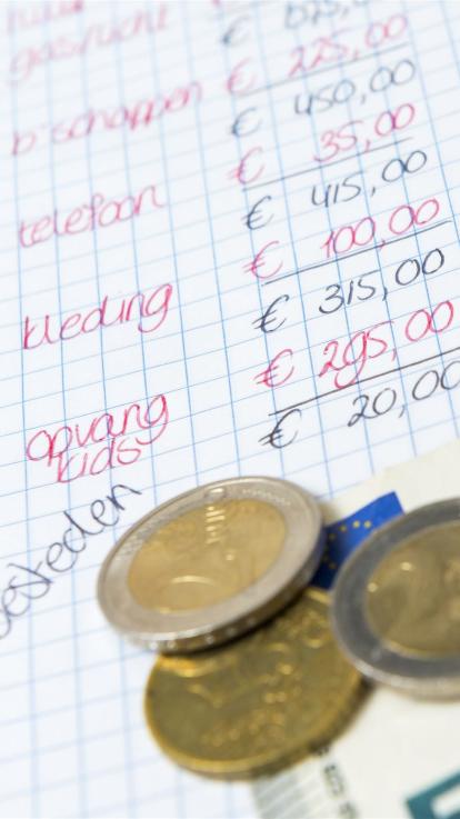 Brief met overzicht van alle uitgaven van een huishouden en euromunten ernaast
