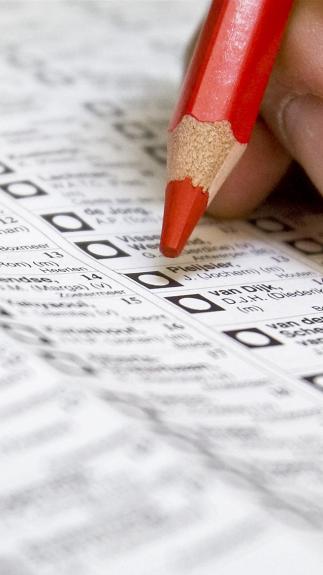 hand met rood potlood boven een stembiljet