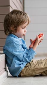 kind kijkt op het scherm van de mobiele telefoon