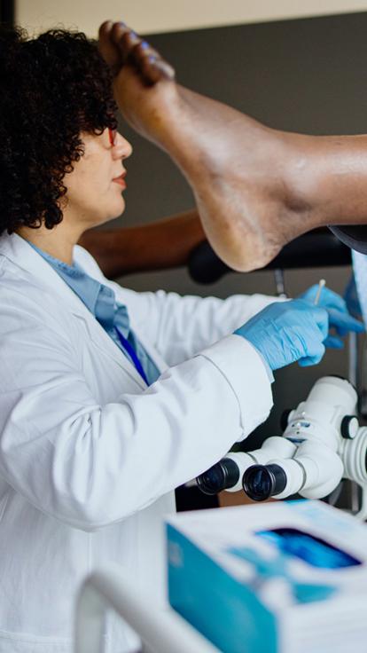 Gynaecoloog kijkt tussen benen die in behandelstoel omhoog liggen