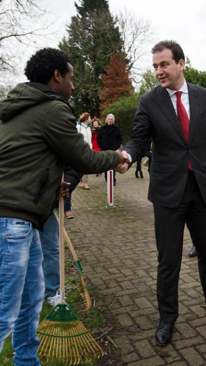 vluchteling geeft Asscher hand