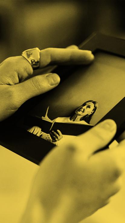 iemand die rouwt en kijkt naar een foto van een dierbare die overleden is