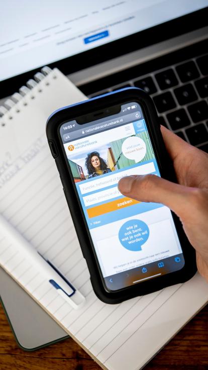 iemand kijkt op de nationale vacaturebank-website op diens mobiel