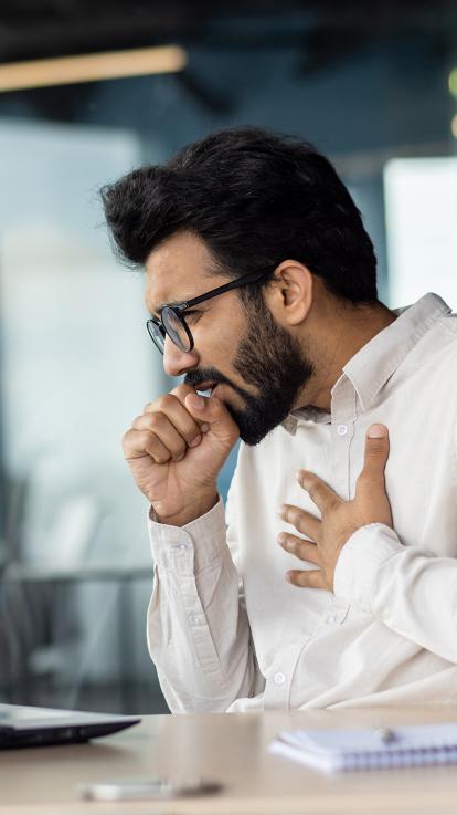 Man hoest in zijn vuist 