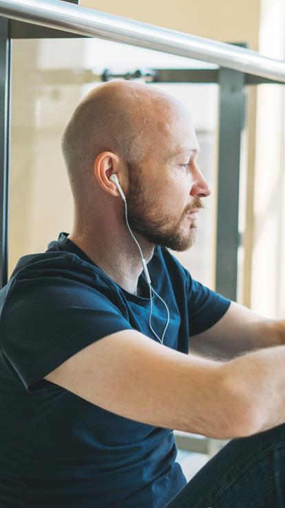 kale jonge man die muziek aan het luisteren is