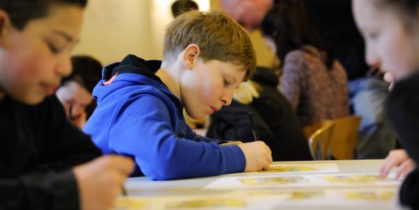 jongen wekt op school aan een schoolopdracht