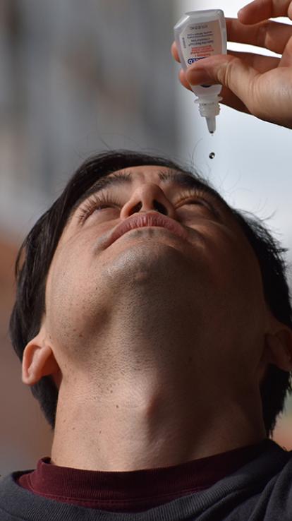 iemand doet oogdruppels in z'n oog