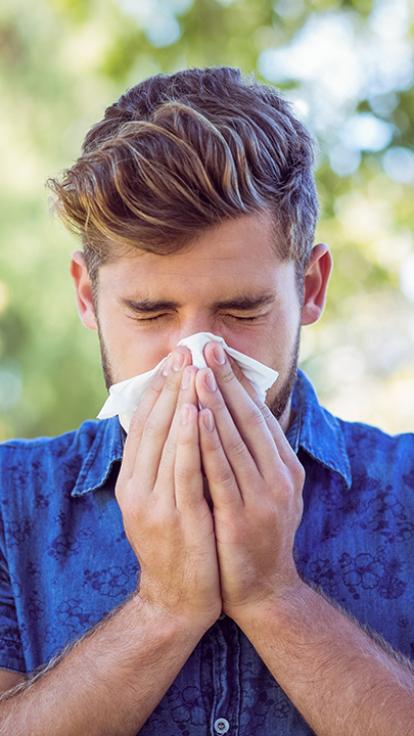 een man niest in een zakdoek