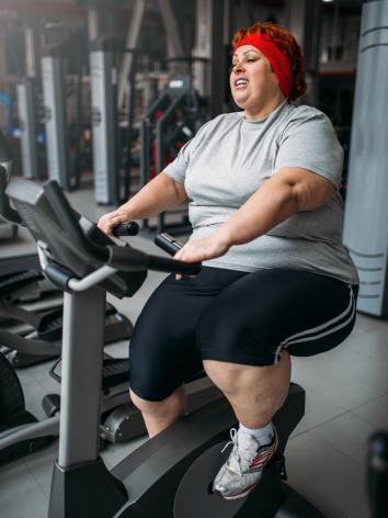 vrouw met overgewich aan het afvallen in de fitness