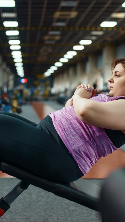 vrouw werkt aan haar gewicht in de sportschool