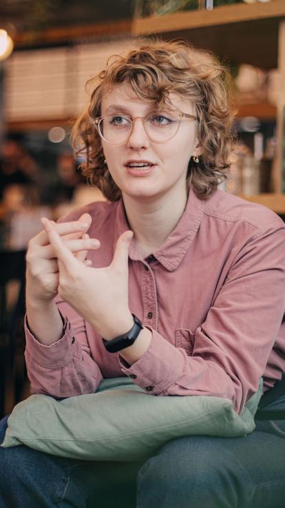 Iemand zit op een stoel in een café en is aan het praten