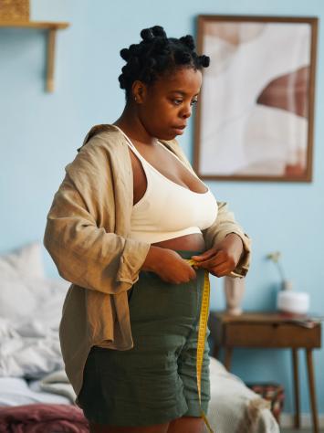 Een vrouw meet haar buikomvang op