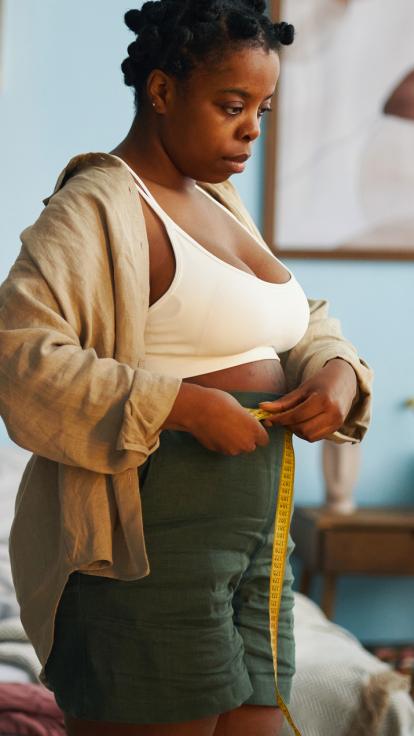 Een vrouw meet haar buikomvang op