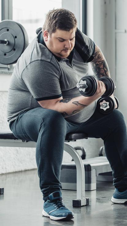 man met ernstig overgewicht in de sportschool om af te vallen