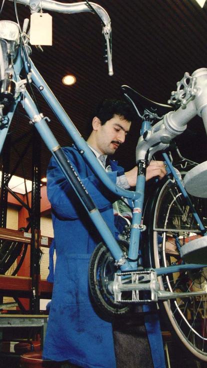 Werkloze jongere sleutelt aan een fiets.