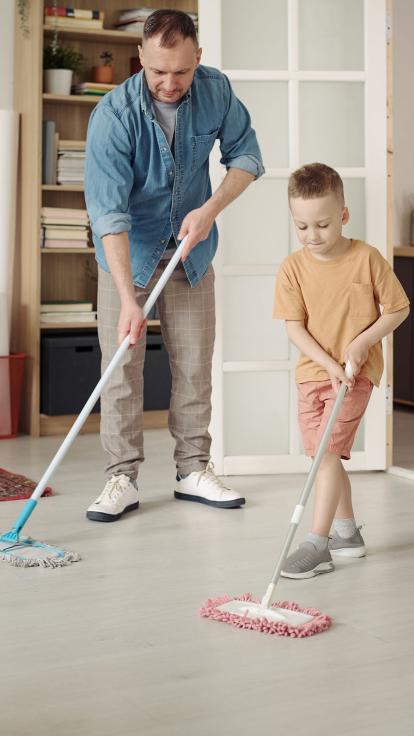een vader maakt het huis schoon met zijn zoon