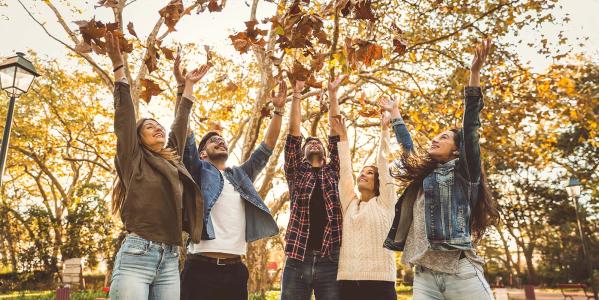 Mensen gooien herfstblaadjes in de lucht herfst
