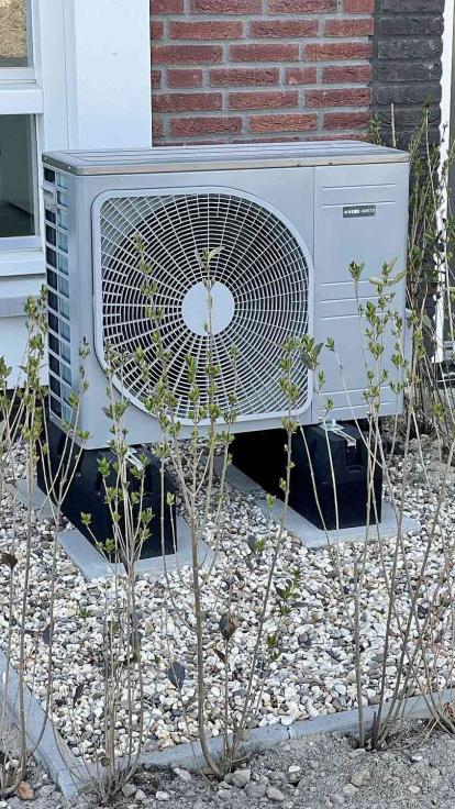 Een warmtepomp in een voortuin