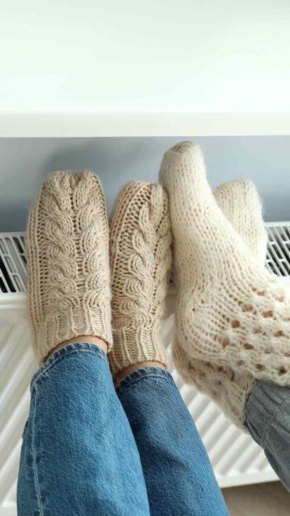 Warme wintersokken op de kachel en verwarming tegen koude voeten