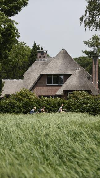 Kinderen fietsen langs een villa in 't Gooi