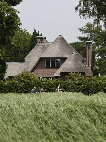 Kinderen fietsen langs een villa in 't Gooi