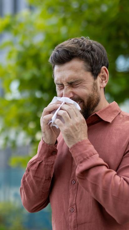 Een man moet niesen.