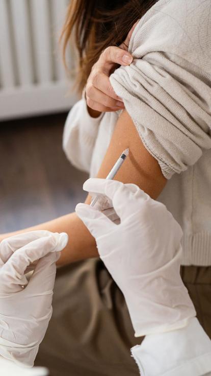 Een vrouw krijgt een griepprik.