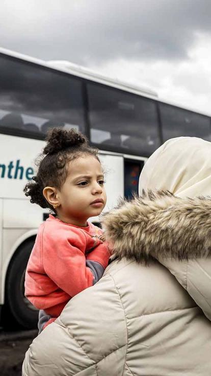 Vluchtelingen komen aan in Nederland bij een asielzoekerscentrum