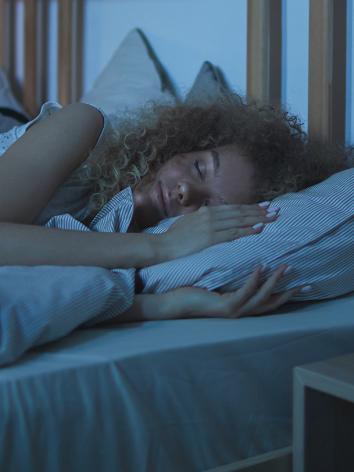 Vrouw ligt op bed te slapen
