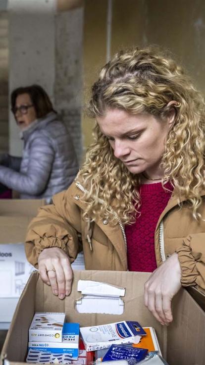 Vrijwilligers van een inzamelactie nemen spullen in ontvangst